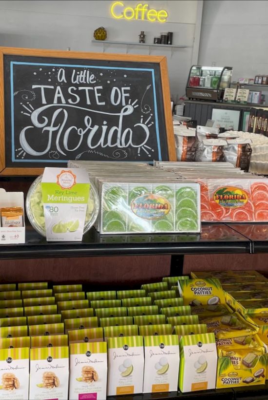 The image shows a display of citrus-themed products with a sign that says “A little taste of Florida,” in a store with sections for coffee and pizza.